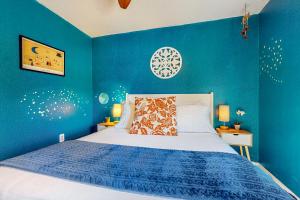 a blue bedroom with a bed with a blue wall at Bluebonnet Bungalow in Austin