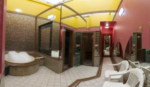 y baño con bañera, lavabo y espejos. en Status Motel - Check In Livre, en Serra