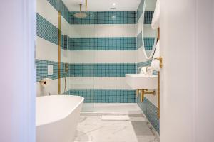 a bathroom with a tub and a sink at The Nici in Bournemouth