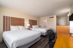 a hotel room with two beds and a desk at Nevada Flats Hotel in Colorado Springs