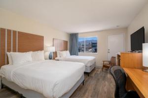 Cette chambre comprend deux lits et une télévision. dans l'établissement Nevada Flats Hotel, à Colorado Springs