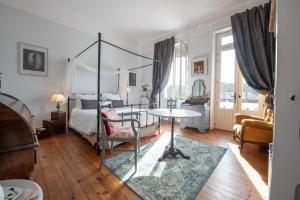 ein Schlafzimmer mit einem Himmelbett und einem Tisch darin in der Unterkunft Villa Hortebise in Salies-de-Béarn