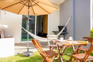 奧克斯特派克的住宿－Sierra Apartments- Estudios Oaxtepec，桌椅、遮阳伞和吊床