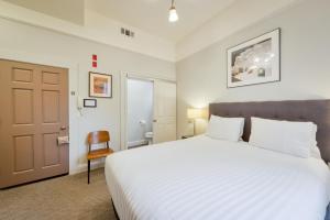 a bedroom with a large white bed and a door at The Grove Inn in San Francisco