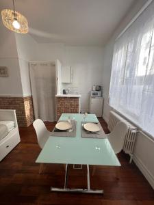 cocina con mesa y sillas en una habitación en Le cottage des lumières, en Boulogne-sur-Mer