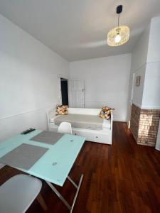 Habitación con cama, mesa y sillas. en Le cottage des lumières, en Boulogne-sur-Mer