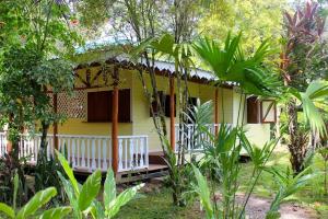 een geel huis met een veranda in een bos bij Casa Amarilla in Puerto Viejo