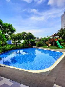 a swimming pool with a slide and a playground at AIR Residences-A Home to Remember by Luca's Cove in Manila