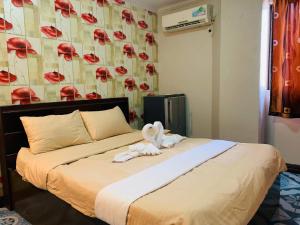 a bed with a stuffed animal sitting on top of it at Drake Hotel Angeles City in Angeles