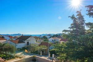 une vue sur une banlieue résidentielle avec le soleil dans le ciel dans l'établissement Spacious apartments with pool, Pakoštane, à Pakoštane