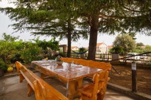 une table en bois entourée de 2 chaises en bois dans l'établissement Spacious apartments with pool, Pakoštane, à Pakoštane