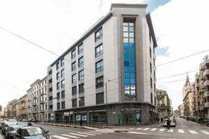Un edificio en una calle con coches aparcados delante. en Enjoy Room- Appartamento con parcheggio GRATUITO e COLAZIONE DELIZIOSA !, en Turín