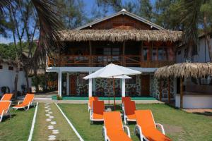 ein Resort mit Stühlen, einem Sonnenschirm und einem Gebäude in der Unterkunft HANGA ROA HOTEL in Montañita