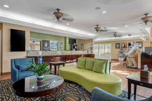 een woonkamer met een groene bank en een tafel bij Best Western Cocoa Beach Hotel & Suites in Cocoa Beach