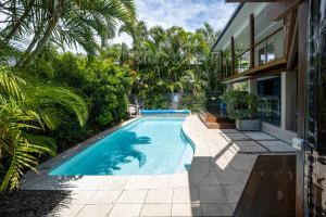a swimming pool in the backyard of a house at Four Beaches-LJHooker Yamba in Yamba