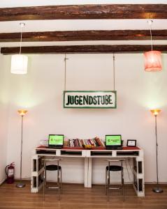 a table with two laptops on it in a room at JugendStube Hostel in Braşov