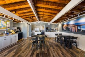 a kitchen with wooden ceilings and tables and chairs at Pacific Coast Roadhouse Hotel in San Simeon