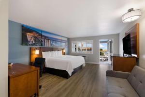 Pacific Coast Roadhouse Hotel في سان سيموان: غرفه فندقيه بسرير واريكه