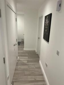 un pasillo vacío con paredes blancas y suelo de madera en East London - 2 bed Apartment with Parking en Barking