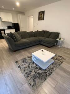 sala de estar con sofá y mesa sobre una alfombra en East London - 2 bed Apartment with Parking en Barking
