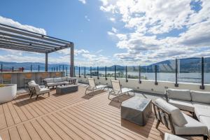 una terraza en un crucero con sillas y mesas en Brand New Luxury Downtown Near the Beach #10, en Kelowna