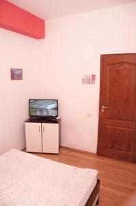 Habitación con TV y puerta. en JugendStube Hostel en Brasov