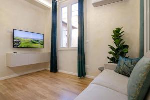 salon z kanapą i telewizorem na ścianie w obiekcie Portanova Luxury Home w Bolonii