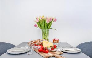 a table with a plate of cheese and a vase of flowers at Nice Apartment In Lembruchdümmer See in Lembruch