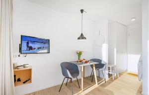 a white dining room with a table and two chairs at Nice Apartment In Lembruchdümmer See in Lembruch