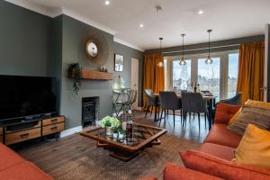 a living room with a couch and a television at Luxury Renovated Bungalow with wheel chair access, Hot Tub and Fire Pit 