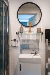 a bathroom with a sink and a mirror at Luxury Renovated Bungalow with wheel chair access, Hot Tub and Fire Pit 