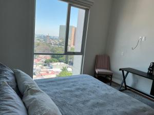 a bedroom with a bed and a large window at Penthouse Minerva in Guadalajara