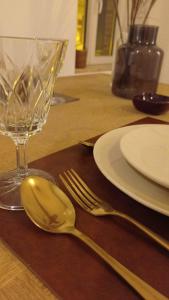 a wooden table with a spoon and fork and a glass at Les Réserves du Beffroi in Aire-sur-la-Lys