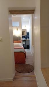 um pequeno quarto com uma cama e uma cozinha em Les Réserves du Beffroi em Aire-sur-la-Lys
