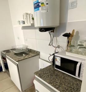 cocina con microondas y encimera en Hermoso departamento con balcón en Córdoba