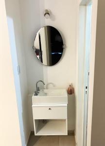 y baño con lavabo y espejo. en Hermoso departamento con balcón en Córdoba