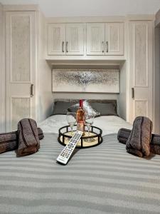 una cama con control remoto encima en 3 bed home in Tonypandy with Balcony View Room en Llwyn-y-pia