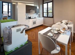 kuchnia ze stołem, krzesłami i maszyną w obiekcie GIO'EL Happiness Guest House w Bergamo