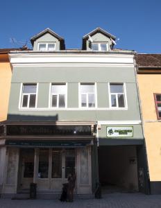 a white building with people standing outside of it at JugendStube Hostel in Braşov