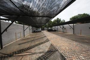 a roof over a road with cars parked on it at OKE Apart Hotel in San Lorenzo