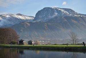 a mountain in the background with a body of water at Craiglea Cottage, self catering highland cottage. in Fort William