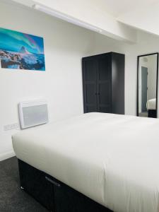 a large white bed in a room with at Beautiful 4 Bedroom 2 bathroom House close to city centre in Leeds +4 photos