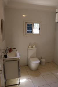 a bathroom with a toilet and a sink and a window at The Rink Apartment's in Sukuta +66 photos
