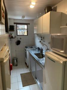 a small kitchen with a sink and a microwave at Casa da Baía in Angra dos Reis +20 photos