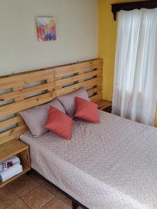 um quarto com uma cama com almofadas vermelhas e cinzentas em AZURA HOTEL BOUTIQUE em Cobán