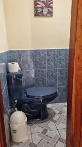 a bathroom with a blue toilet and a bucket at AZURA HOTEL BOUTIQUE in Cobán
