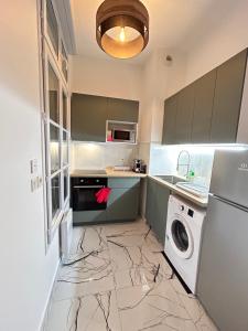 cocina con suelo de mármol, lavadora y secadora en MD Apartment Terrace - Disneyland Paris en Serris