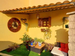 un patio con reloj y una mesa con plantas en Sleeping Sarria, en Sarria