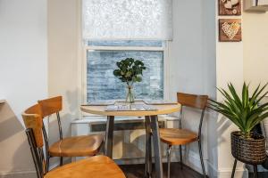 a table and chairs in a room with a window at Spacious & Cosy Studio Flat in the Heart of Edinburgh City Centre in Edinburgh