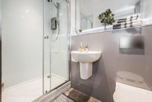 a bathroom with a toilet and a sink and a shower at Spacious & Cosy Studio Flat in the Heart of Edinburgh City Centre in Edinburgh